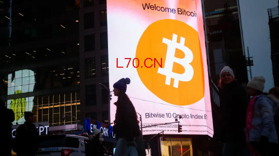 2025 年 12 月 9 日美国纽约时代广场的比特币广告牌。加密市场仍未从 10 月 10 日闪崩行情中恢复，当日超 190 亿美元加密资产仓位被强制平仓；现货成交量较今年 1 月峰值萎缩 66%。